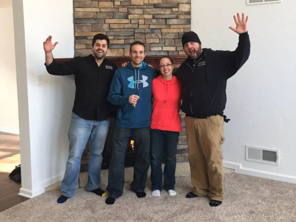 Parry home builder team posing in front of a fireplace