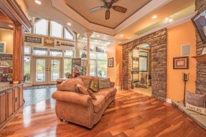 custom living room showing couch, brown brick, orange water, wood floor